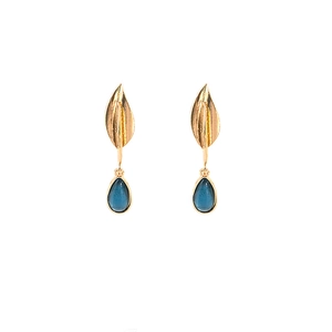 Detailed close-up of golden leaf stud earrings with blue teardrop pendants on white background