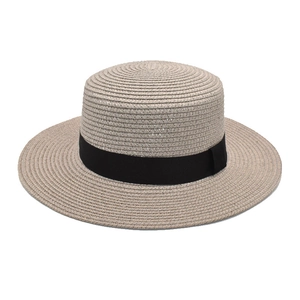 Detailed texture of fine weave straw sun hat with elegant black ribbon band detail