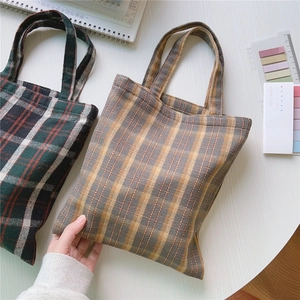 Detailansicht von karierten Canvas-Tragetaschen im Retro-britischen Stil auf Tisch