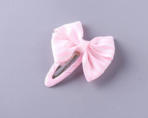 Close-up of a pink striped ribbon bow hair clip with a fabric wrapped metal base