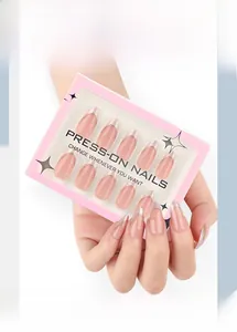 Close-up of pink ombre press-on nails with silver French tips in a retail display box