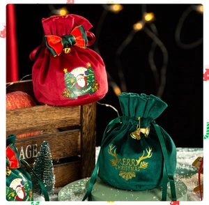 Detail of red and green velvet Christmas drawstring gift bags with festive golden lettering