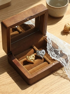 Detail der gehämmerte Herzohrringe in Gold und Silber in einer edlen Holzkiste aus Holz