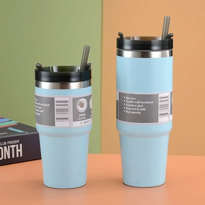 Close-up of matte light blue stainless steel tumblers with black lids and grey straws