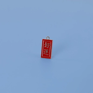 Détail du pendentif en métal émaillé rouge avec caractère chinois porte-bonheur argenté