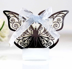 Detail of laser-cut butterfly favor box with elegant white ribbon for wedding gifts