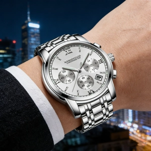 Close-up of an elegant men's stainless steel watch featuring luminous hands and date window.