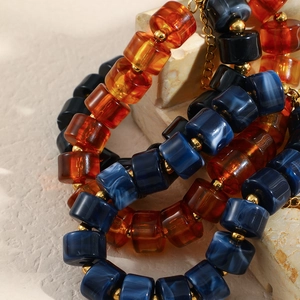 Bracelet élégant avec perles en acrylique ambre, cylindres bleus et accents dorés
