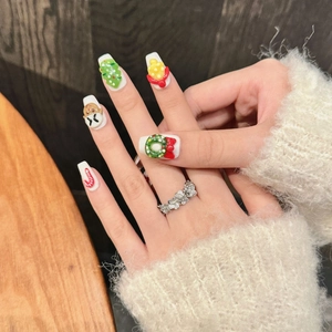 3D Christmas themed press-on nails with gingerbread and tree charms on white base