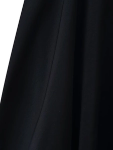 Gros plan sur le tissu noir mat montrant la texture du matériau et le drapé du vêtement