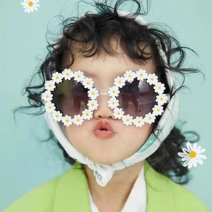 Kids daisy flower sunglasses with white petals and dark lenses on mint background