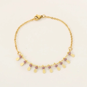 Detailed view of golden link bracelet featuring lavender beads and drop metal charms