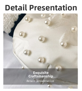 Detail of white satin shell bag featuring elegant jacquard texture and pearl beads