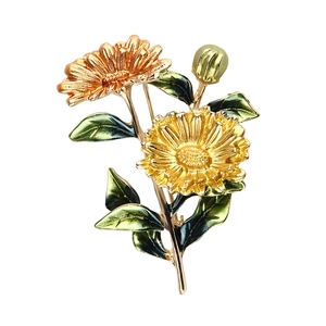 Eleganter goldener Blumenanstecker mit Emaille-Blüten und grünen Blättern auf Weiß
