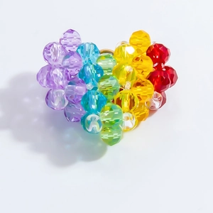 Macro shot of faceted rainbow beads woven into a heart-shaped pendant for DIY jewelry