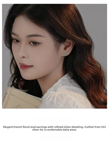 Detail of S925 silver floral earring with green gemstone on a model with french vintage style