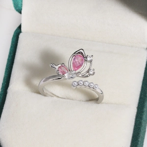 Close-up of pink zircon butterfly ring with white pearls on a velvet jewelry box
