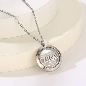 Detailed shot of silver locket necklace with mae engraving and pearls on white background