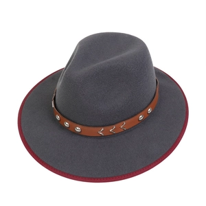 Detail view of charcoal gray felt fedora with brown leather band and red stitched brim