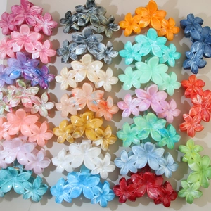 Flat lay display of colorful flower hair claws with elegant marble textured finish
