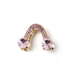 Détail macro de la pince à cheveux triangle dorée avec strass et cristaux roses
