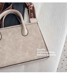 Detailed macro of beige cracked leather texture and jacquard strap on a tote bag