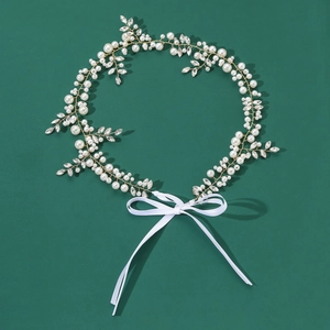 Détail d'un bandeau de mariée avec perles blanches et cristaux sur fil doré