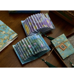 Detailed view of accordion book lamps featuring Van Gogh Starry Night with green tassel