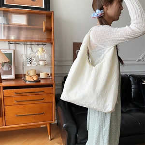 Detailansicht der weißen Chiffon-Tasche mit aufwendiger Blumenstickerei und Stoffstruktur