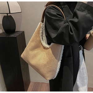Close-up detail of soft suede fabric and plush shearling trim on the contrast tote bag