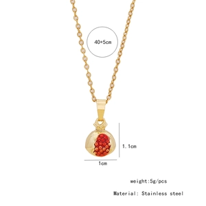 Détail du pendentif grenade dorée avec perles rouges sur chaîne en acier inoxydable