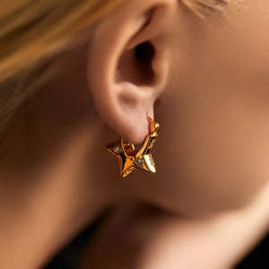 Polished 18K gold-plated star hoop earrings with sparkling cubic zirconia on a model