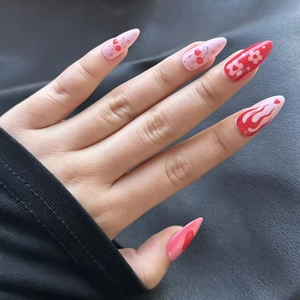 Detail of red cherry and flame pattern on stiletto-shaped Y2K style press-on nails