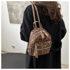 Chic mini leopard print backpack shown from a side view on a female model