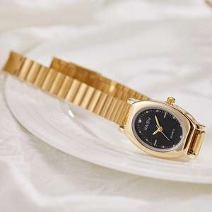 Elegant gold oval watch for women with black dial and stone markers on white background