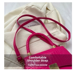 Close-up of rose red crocodile pattern bag with woven handle and gold hardware on white suit