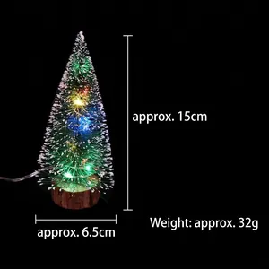 Miniature snow-dusted green Christmas tree with LED lights on a wooden base 15cm