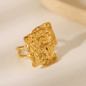 Detailed macro view of the irregular hammered texture on this golden stainless steel ring