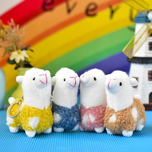 Detailed view of four colorful miniature plush alpaca keychain charms standing in a row