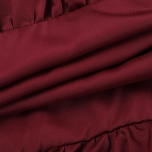 Close-up of wine red satin fabric featuring dense ruffle details and premium texture