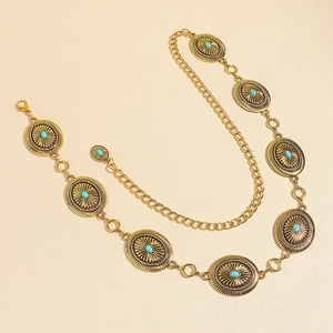 Close-up of vintage golden metal waist chain with embossed turquoise floral details