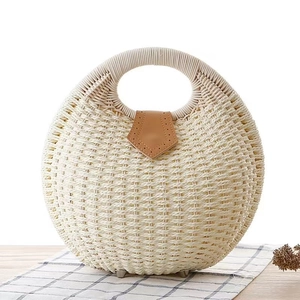 Handwoven straw seashell handbag with round handles and brown leather buckle detail