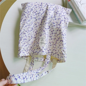 Detailed close-up of a floral canvas tote bag with a woven label and soft inner lining