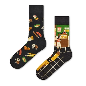 Detail of cotton crew socks featuring mismatched black and green snack stall jacquard pattern