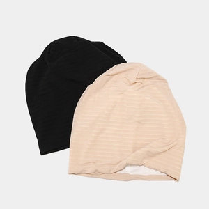 Detail view of double-layer knit beanies showing horizontal slub texture in black and beige