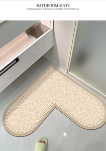 L-shaped beige diatomaceous mud bath mat with floral pattern in bathroom corner