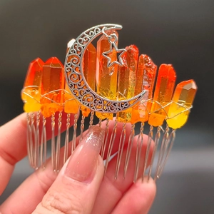 Makroansicht von handgefertigtem Haarkamm mit orangefarbenen Kristallen und Mond-Stern-Anhänger