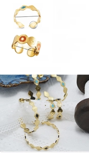 Detail view of gold stainless steel open rings with turquoise and black enamel inlay