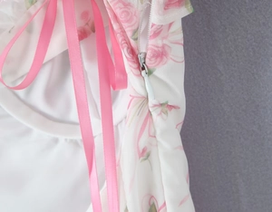 Detailed macro view of invisible zipper and pink floral chiffon fabric on back of dress