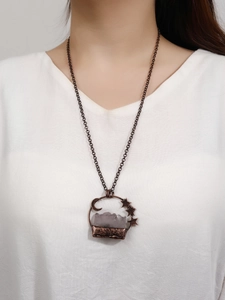Close-up of vintage moon and star pendant with raw purple amethyst on model